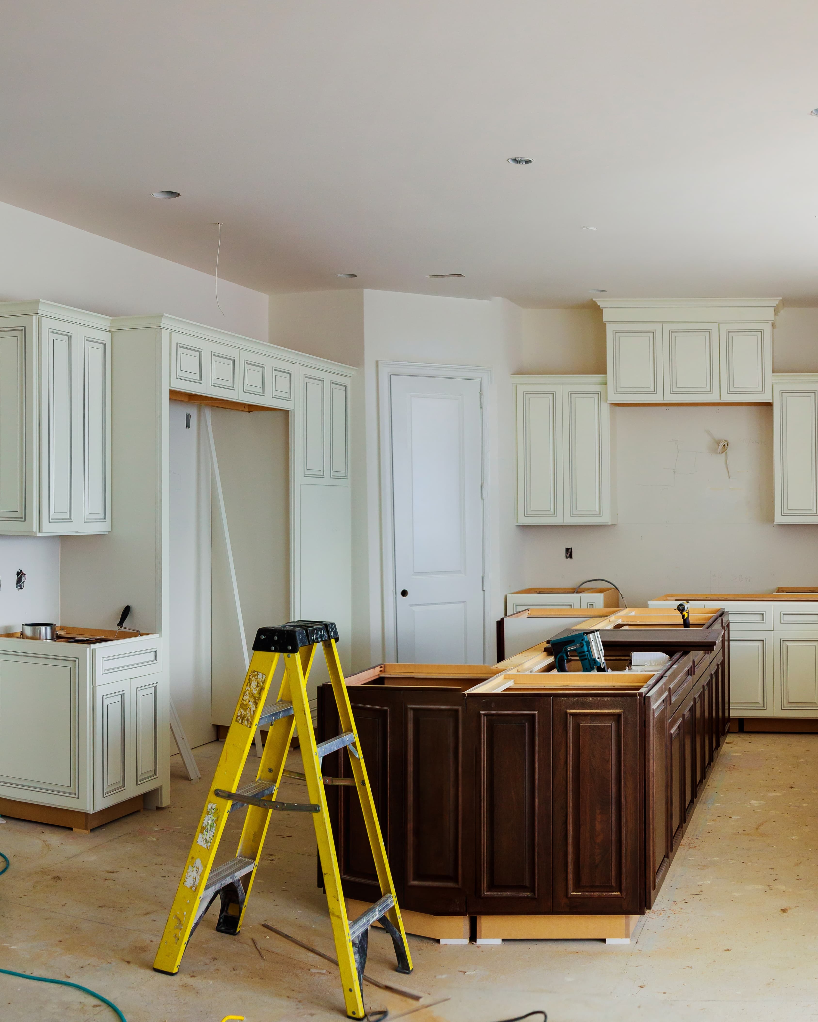Residential kitchen mid-renovation with new cabinets being installed